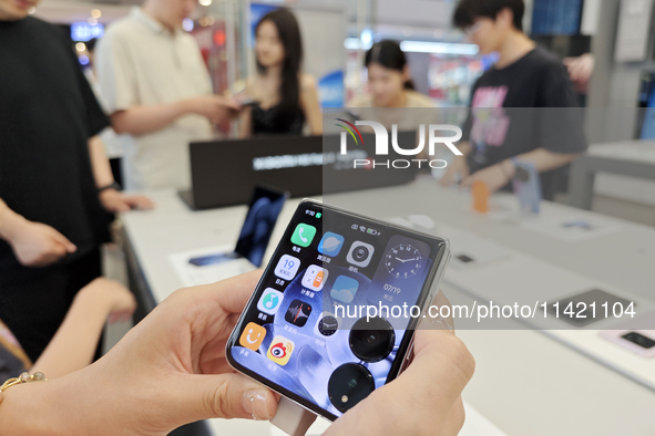 Customers are experiencing the Mi MIX Flip foldable screen phone at a Xiaomi store in Tongling, China, on July 19, 2024. 