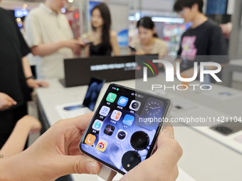 Customers are experiencing the Mi MIX Flip foldable screen phone at a Xiaomi store in Tongling, China, on July 19, 2024. (