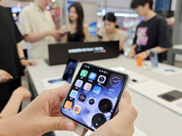 Customers are experiencing the Mi MIX Flip foldable screen phone at a Xiaomi store in Tongling, China, on July 19, 2024. (