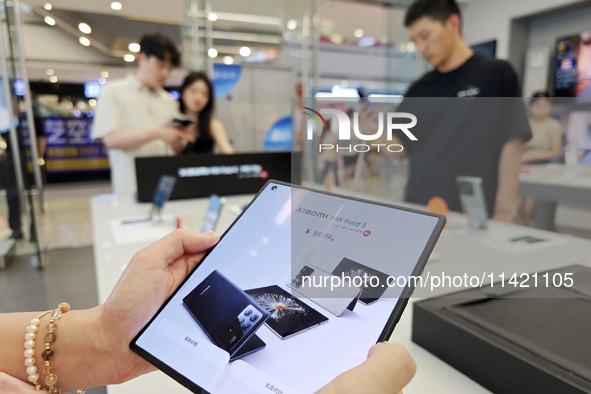 Customers are experiencing the Xiaomi MIX Fold 4 foldable screen phone at a Xiaomi store in Tongling, Anhui province, China, on July 19, 202...