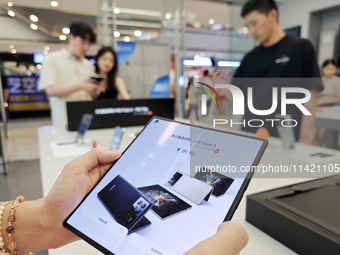 Customers are experiencing the Xiaomi MIX Fold 4 foldable screen phone at a Xiaomi store in Tongling, Anhui province, China, on July 19, 202...