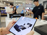 Customers are experiencing the Xiaomi MIX Fold 4 foldable screen phone at a Xiaomi store in Tongling, Anhui province, China, on July 19, 202...