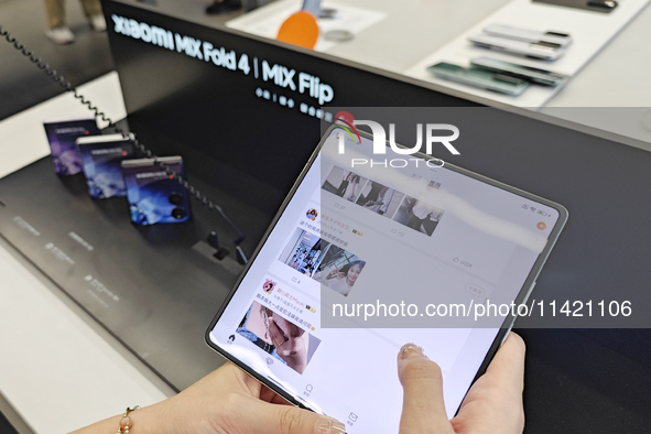 Customers are experiencing the Xiaomi MIX Fold 4 foldable screen phone at a Xiaomi store in Tongling, Anhui province, China, on July 19, 202...