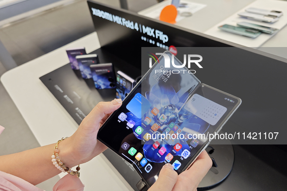 Customers are experiencing the Xiaomi MIX Fold 4 foldable screen phone at a Xiaomi store in Tongling, Anhui province, China, on July 19, 202...