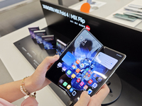 Customers are experiencing the Xiaomi MIX Fold 4 foldable screen phone at a Xiaomi store in Tongling, Anhui province, China, on July 19, 202...