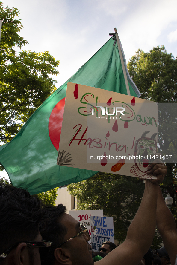 A demonstrator of the Bangladeshi community is showing a sign with the words ''Step Down Hasina'' during a rally in front of the Bangladesh...