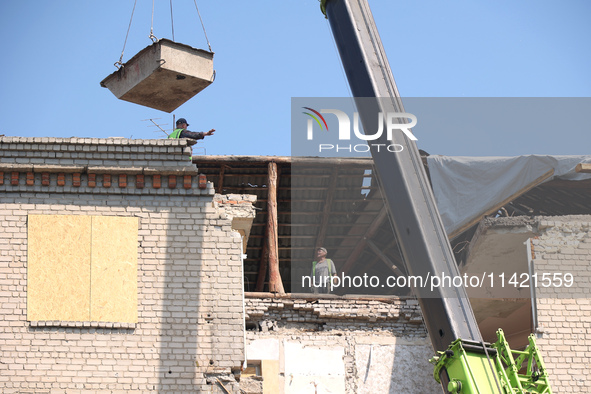 Workers are responding to the aftermath of a Russian missile attack on a residential apartment building in Kharkiv, Ukraine, on July 17, 202...