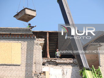 Workers are responding to the aftermath of a Russian missile attack on a residential apartment building in Kharkiv, Ukraine, on July 17, 202...