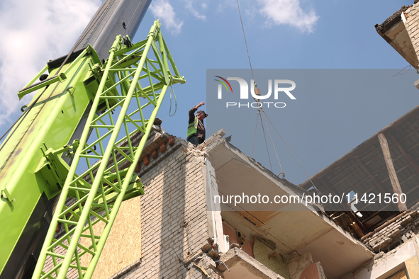 A worker is responding to the aftermath of a Russian missile attack on a residential apartment building in Kharkiv, Ukraine, on July 17, 202...