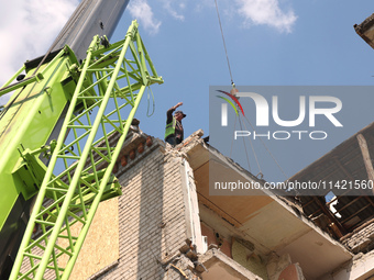 A worker is responding to the aftermath of a Russian missile attack on a residential apartment building in Kharkiv, Ukraine, on July 17, 202...