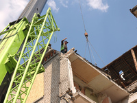 A worker is responding to the aftermath of a Russian missile attack on a residential apartment building in Kharkiv, Ukraine, on July 17, 202...