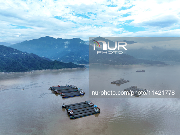 Ships are docking in the upstream waters of the Three Gorges Dam after the water level has dropped and are waiting to pass through the sluic...