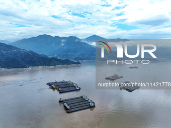 Ships are docking in the upstream waters of the Three Gorges Dam after the water level has dropped and are waiting to pass through the sluic...