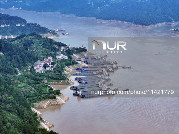 Ships are docking in the upstream waters of the Three Gorges Dam after the water level has dropped and are waiting to pass through the sluic...