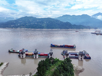 Ships are docking in the upstream waters of the Three Gorges Dam after the water level has dropped and are waiting to pass through the sluic...