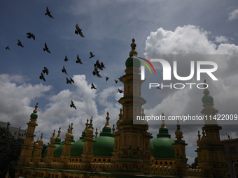 Pigeons are flying over the Tipu Sultan Shahi Mosque as monsoon clouds are gathering in the sky in Kolkata, India, on July 20, 2024. The Tip...