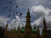 Pigeons are flying over the Tipu Sultan Shahi Mosque as monsoon clouds are gathering in the sky in Kolkata, India, on July 20, 2024. The Tip...