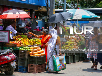 Merchants are selling fruits along the roadside in the East Fort in Thiruvananthapuram (Trivandrum), Kerala, India, on April 13, 2024. (