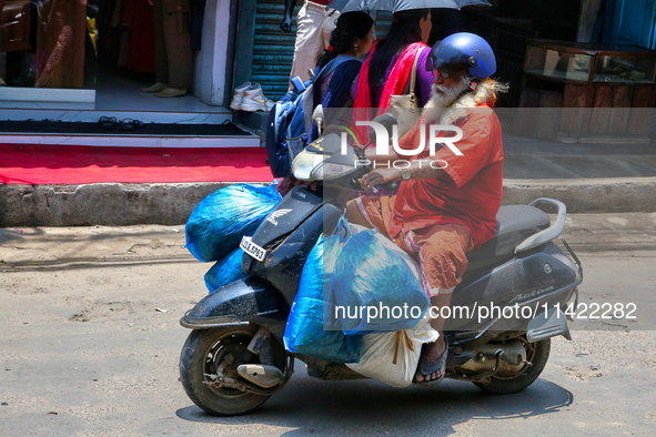 A man is carrying several bags on his scooter in the East Fort area in Thiruvananthapuram (Trivandrum), Kerala, India, on April 13, 2024. 