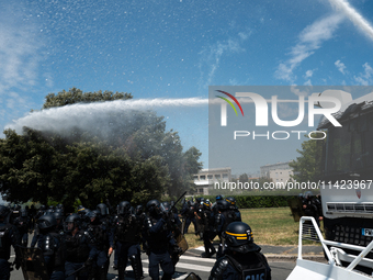 Riot police officers are using a water cannon against demonstrators taking part in a rally against the construction of a giant water reservo...