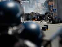 Protesters are protecting themselves behind a barricade created using rubbish cans and makeshift shields during a rally against the construc...