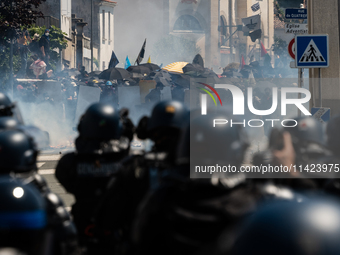 Protesters are protecting themselves behind a barricade created using rubbish cans and makeshift shields during a rally against the construc...