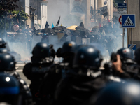 Protesters are protecting themselves behind a barricade created using rubbish cans and makeshift shields during a rally against the construc...