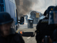 Protesters are protecting themselves behind a barricade created using rubbish cans and makeshift shields during a rally against the construc...