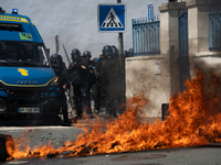 French Gendarmes are standing behind a burning rubbish barricade during a rally against the construction of a giant water reservoir (mega-ba...