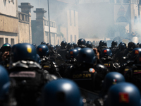 French Gendarmes are wearing riot gear and walking towards the protesters during a rally against the construction of a giant water reservoir...