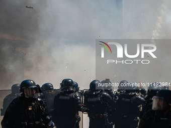 French Gendarmes are wearing riot gear and walking towards the protesters during a rally against the construction of a giant water reservoir...