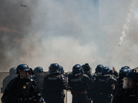 French Gendarmes are wearing riot gear and walking towards the protesters during a rally against the construction of a giant water reservoir...