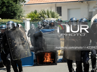 French Gendarmes are wearing riot gear and walking towards the protesters during a rally against the construction of a giant water reservoir...