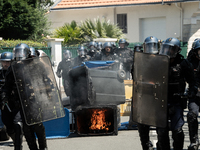 French Gendarmes are wearing riot gear and walking towards the protesters during a rally against the construction of a giant water reservoir...