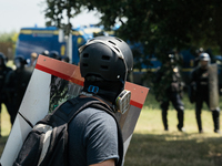 Demonstrators are standing in front of riot police officers during a rally against the construction of a giant water reservoir (mega-bassine...