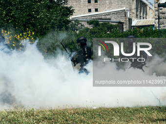 French gendarmes are walking amid the smoke from tear gas during a demonstration against the construction of a giant water reservoir (mega-b...