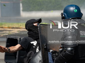 A French Gendarme is wearing riot gear and standing in front of a protester during a rally against the construction of a giant water reservo...