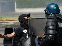 A French Gendarme is wearing riot gear and standing in front of a protester during a rally against the construction of a giant water reservo...