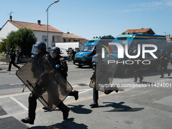 French Gendarmes are wearing riot gear and running towards the protesters during a rally against the construction of a giant water reservoir...