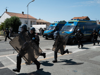 French Gendarmes are wearing riot gear and running towards the protesters during a rally against the construction of a giant water reservoir...