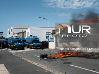 French Gendarmes are standing behind a burning rubbish barricade during a rally against the construction of a giant water reservoir (mega-ba...