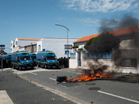 French Gendarmes are standing behind a burning rubbish barricade during a rally against the construction of a giant water reservoir (mega-ba...