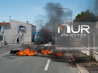 French Gendarmes are standing behind a burning rubbish barricade during a rally against the construction of a giant water reservoir (mega-ba...