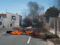 French Gendarmes are standing behind a burning rubbish barricade during a rally against the construction of a giant water reservoir (mega-ba...