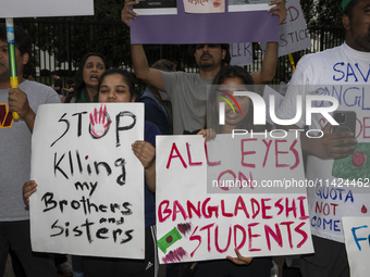 Demonstrators of the Bangladeshi community are displaying signs with the words ''All Eyes On Bangladeshi Students,'' among other informative...