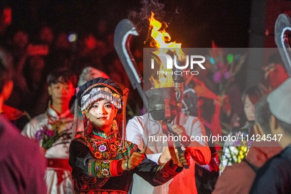 A sacred woman of the Yi ethnic group is escorting fire on the Asilisi grassland in Hezhang county, Bijie city, Southwest China's Guizhou pr...