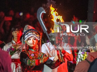 A sacred woman of the Yi ethnic group is escorting fire on the Asilisi grassland in Hezhang county, Bijie city, Southwest China's Guizhou pr...