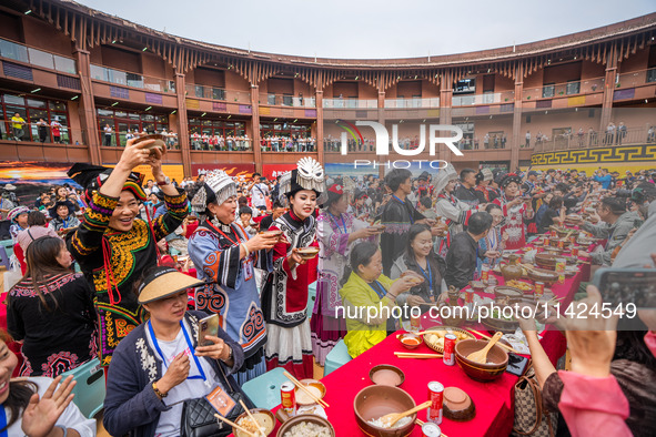 Tourists are enjoying a long table banquet on the Asilisi grassland in Hezhang county, Bijie city, Southwest China's Guizhou province, on Ju...