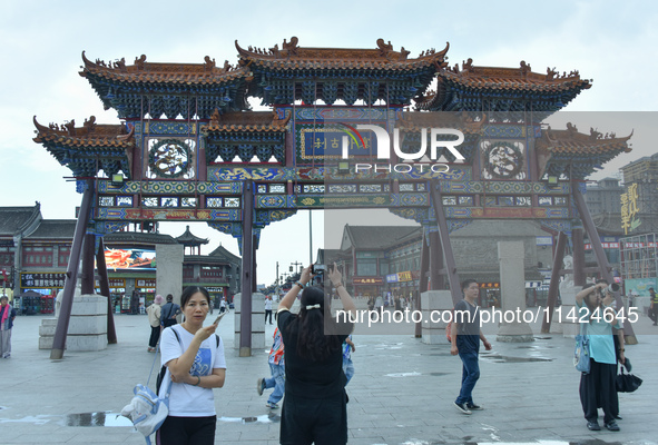 Tourists are enjoying the scenery of Saishang Old Street, the core area of the Saishang Old Street tourism and leisure district, in Hohhot,...