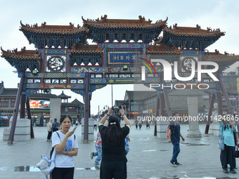 Tourists are enjoying the scenery of Saishang Old Street, the core area of the Saishang Old Street tourism and leisure district, in Hohhot,...